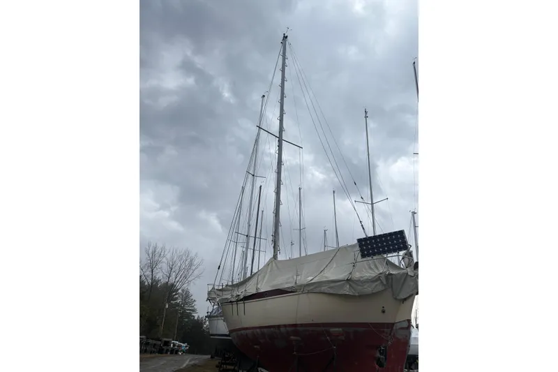 Slide: The Image of 1978 Pacific Seacraft 31 sailboat with covered deck and solar panel under cloudy sky. - 7