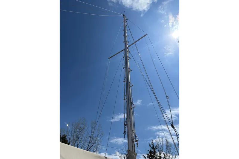 Slide: The Image of Tall mast of a 1978 Pacific Seacraft 31 sailboat against a clear blue sky. - 9