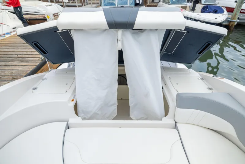 Slide: The Image of 2024 Chaparral 23 SSi OB boat interior with open storage compartments at the dock. - 15