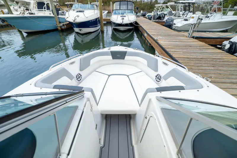 Slide: The Image of 2024 Chaparral 23 SSi OB boat docked, showcasing spacious bow seating and sleek design. - 5