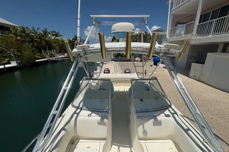 Slide: The Image of 2002 World Cat 246 DC boat docked, featuring dual consoles and fishing rod holders. - 10