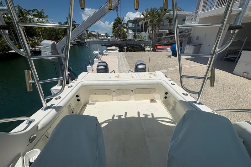 Slide: The Image of 2002 World Cat 246 DC boat docked by waterfront homes under a clear blue sky. - 11