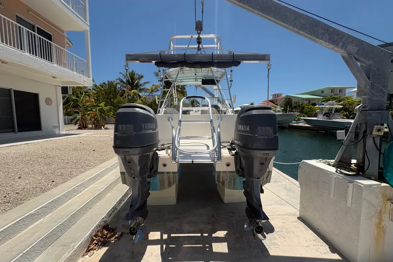 Slide: The Image of 2002 World Cat 246 DC boat with twin Yamaha engines docked near waterfront homes. - 5