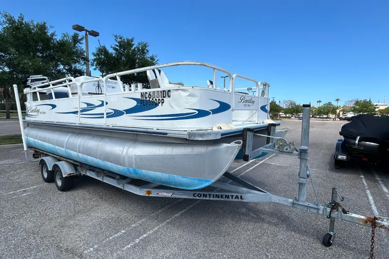 The Image of 2005 Bentley Pontoons 200 Fish on trailer in parking lot, clear sky background. - 0