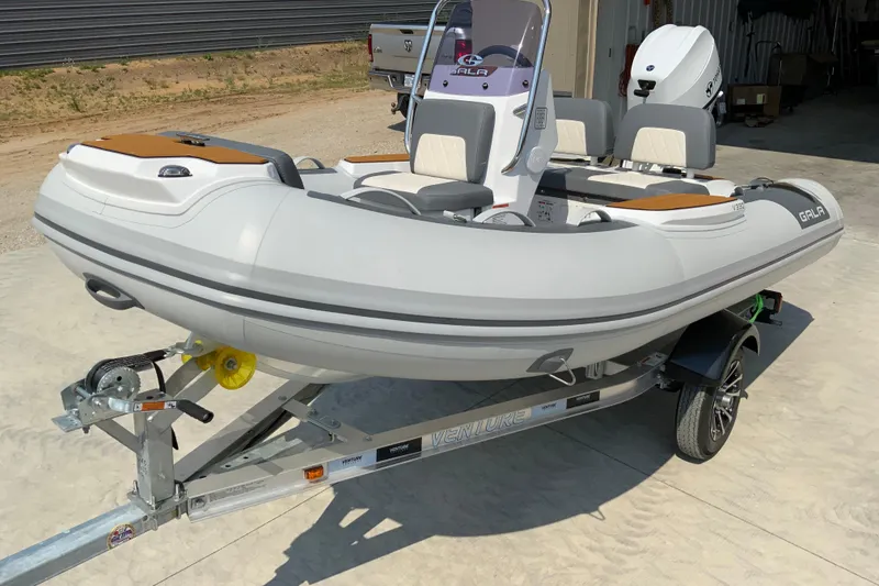 Slide: The Image of 2027 Gala V360 inflatable boat on trailer, parked outdoors in a sunny setting. - 3