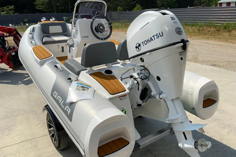 Slide: The Image of 2027 Gala V360 inflatable boat with Tohatsu engine, displayed outdoors on a trailer. - 4