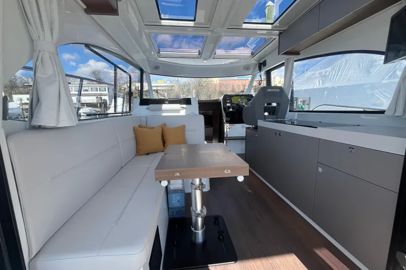 Slide: The Image of Interior of 2026 Beneteau Antares 11 Coupe with modern seating and skylights. - 12