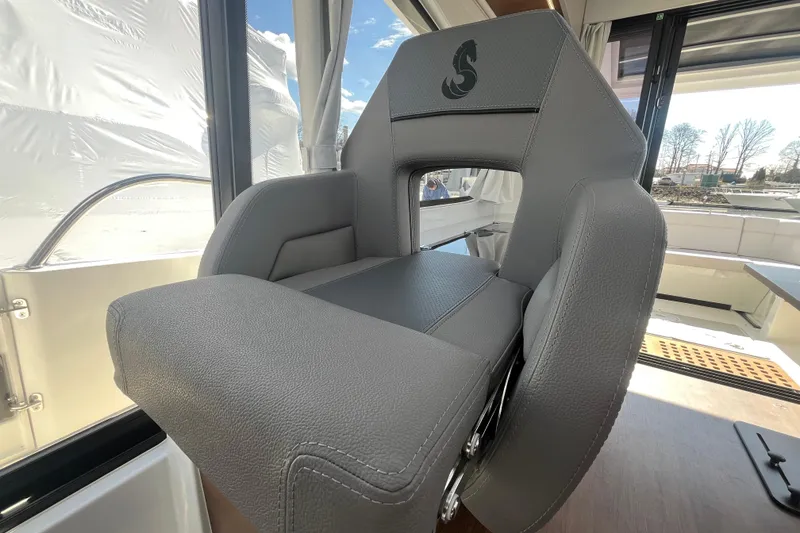 Slide: The Image of Captain's seat on 2026 Beneteau Antares 11 Coupe, featuring sleek gray upholstery. - 13