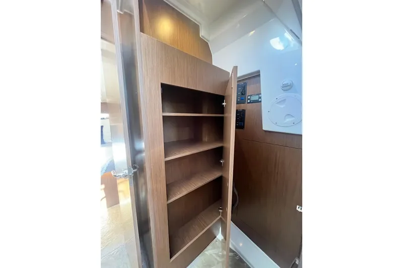 Slide: The Image of Interior shelving of 2026 Beneteau Antares 11 Coupe, featuring wooden finish and ample storage space. - 26