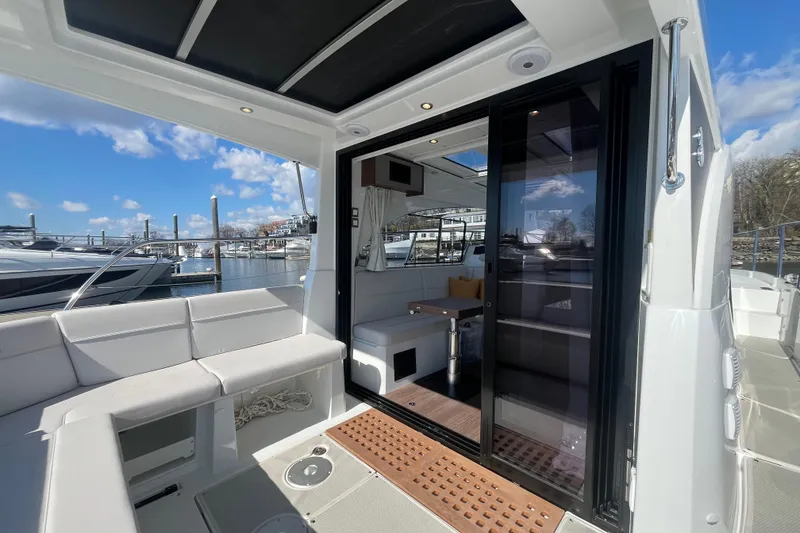 Slide: The Image of 2026 Beneteau Antares 11 Coupe yacht interior with seating and sliding glass door. - 4