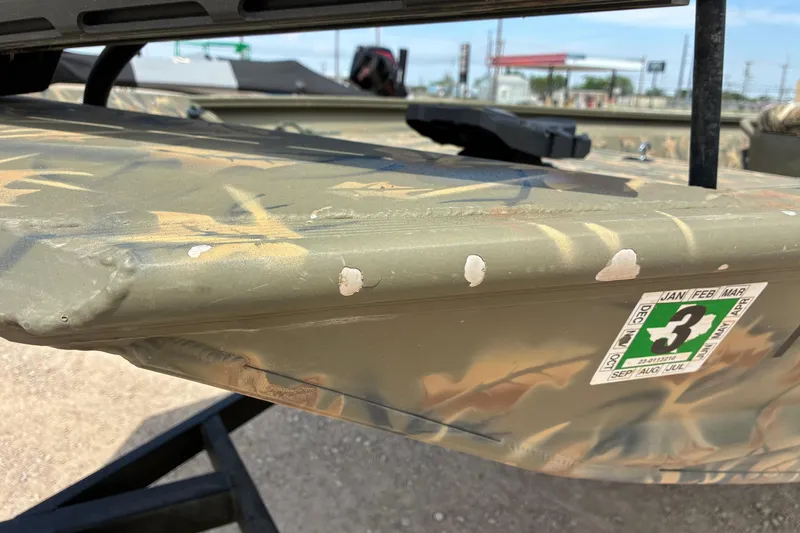 Slide: The Image of 2022 Tracker Grizzly 1860 CC boat with camouflage paint and visible wear marks. - 5
