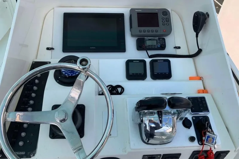 Slide: The Image of Control panel of a 1998 Contender 35 Express Side Console boat with steering wheel and electronics. - 5