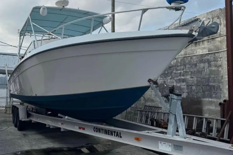 Slide: The Image of 1998 Contender 35 Express Side Console boat on trailer, parked outdoors. - 6