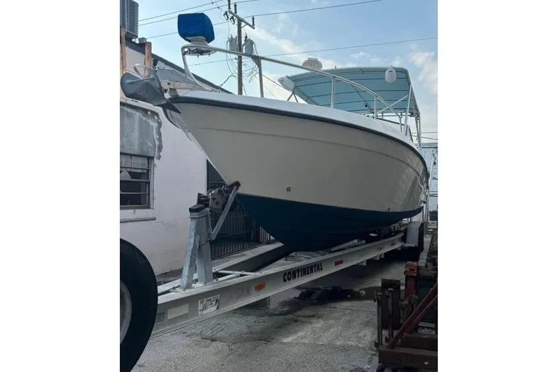 Slide: The Image of 1998 Contender 35 Express Side Console boat on trailer, parked outdoors. - 7