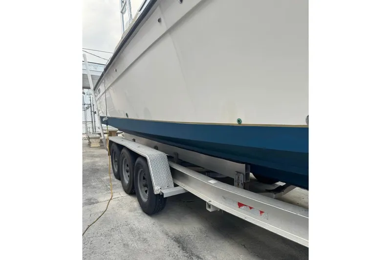 Slide: The Image of 1998 Contender 35 Express Side Console boat on a trailer, viewed from the side. - 8