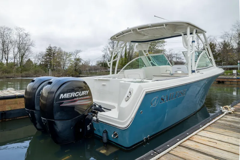 The Image of 2014 Sailfish 275 DC boat docked, featuring twin Mercury engines. - 1