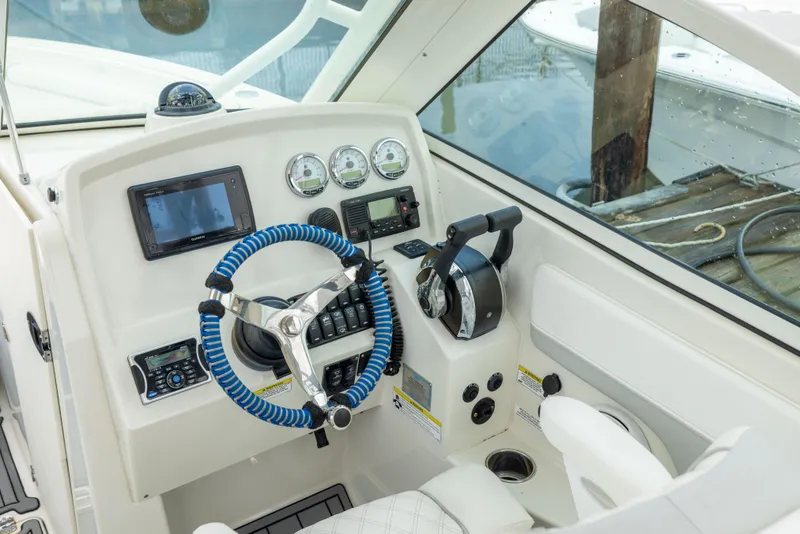 Slide: The Image of 2014 Sailfish 275 DC boat dashboard with steering wheel and navigation controls. - 10