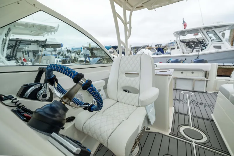 Slide: The Image of Interior of 2014 Sailfish 275 DC boat with steering wheel and seating. - 11