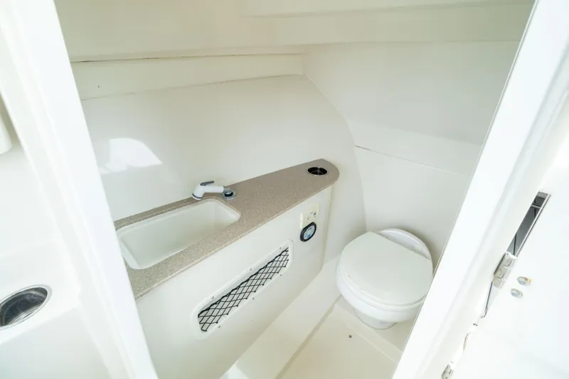 Slide: The Image of 2014 Sailfish 275 DC boat interior bathroom with sink and toilet. - 13