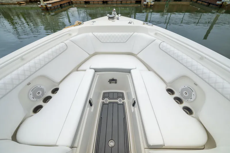 Slide: The Image of 2014 Sailfish 275 DC boat interior with white cushioned seating and cup holders. - 14