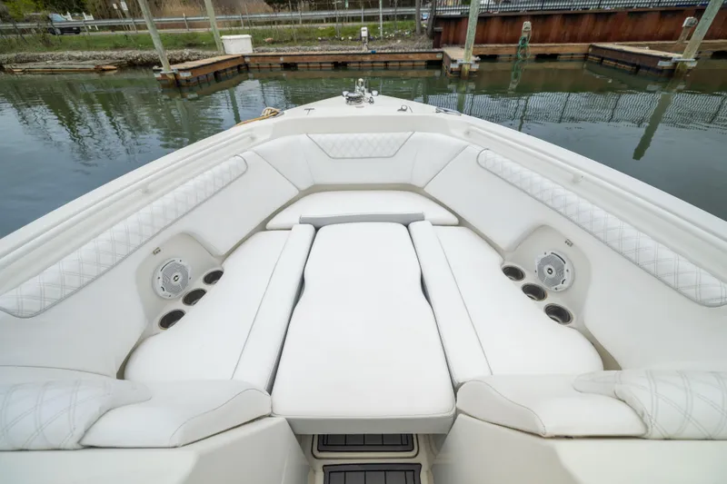 Slide: The Image of 2014 Sailfish 275 DC boat interior with white cushioned seating and cup holders. - 15