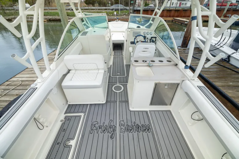 Slide: The Image of 2014 Sailfish 275 DC boat interior with seating, steering, and fishing rod holders. - 4