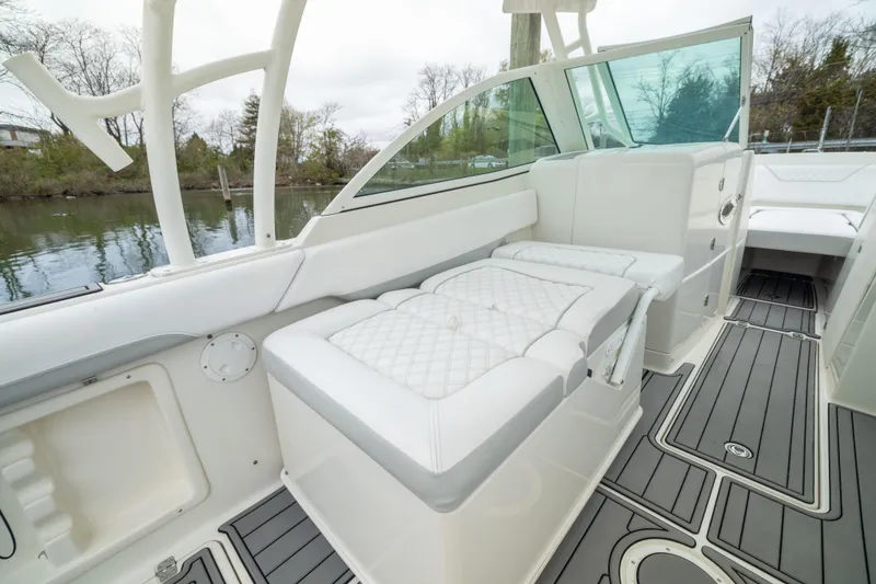 Slide: The Image of 2014 Sailfish 275 DC boat interior with cushioned seating and sleek design. - 7