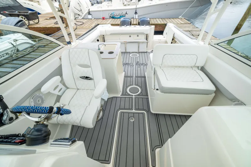 Slide: The Image of 2014 Sailfish 275 DC boat interior with white seating and modern dashboard. - 9