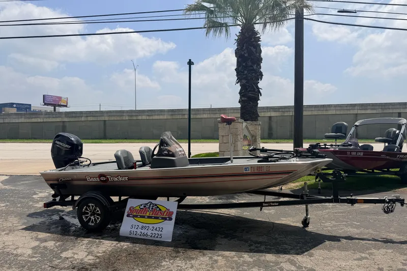 Slide: The Image of 2019 Bass Tracker III Classic boat on trailer, parked outdoors under a cloudy sky. - 28
