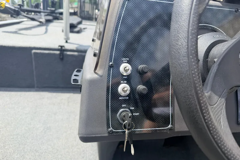 Slide: The Image of 2019 Bass Tracker III Classic dashboard with ignition keys and control switches. - 9