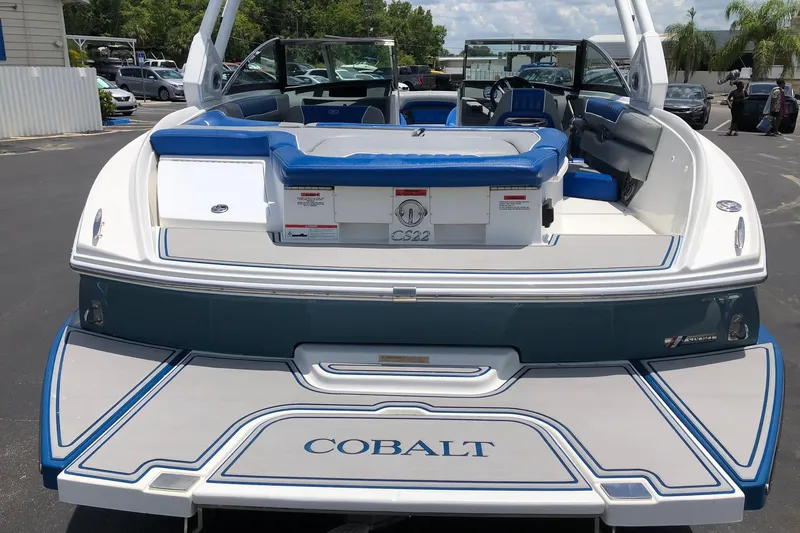 Slide: The Image of 2021 Cobalt CS22 boat with blue and white seating, docked outdoors. - 12
