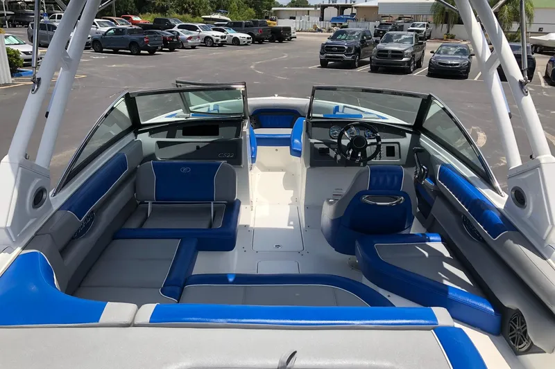 Slide: The Image of 2021 Cobalt CS22 boat interior with blue and gray seating, parked in a lot. - 13