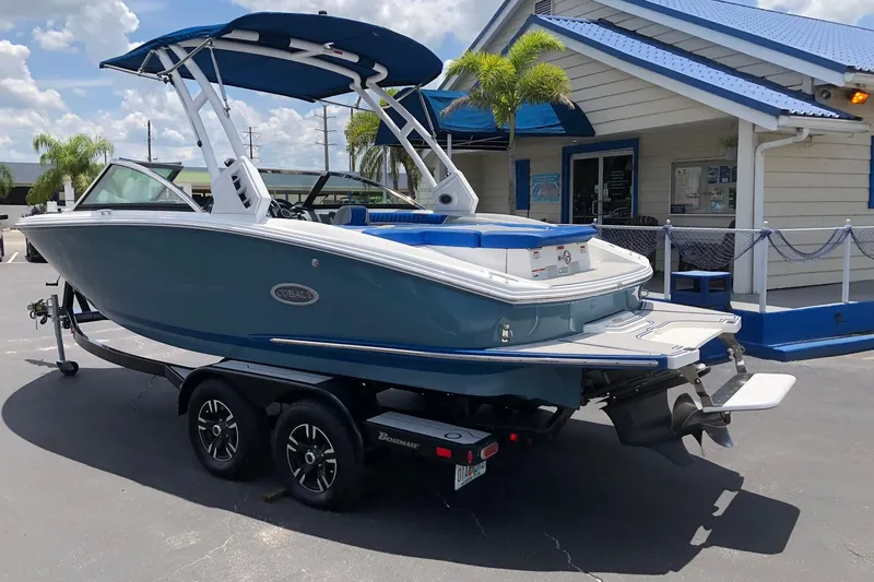 Slide: The Image of 2021 Cobalt CS22 boat on trailer, parked outside a building with blue accents. - 14