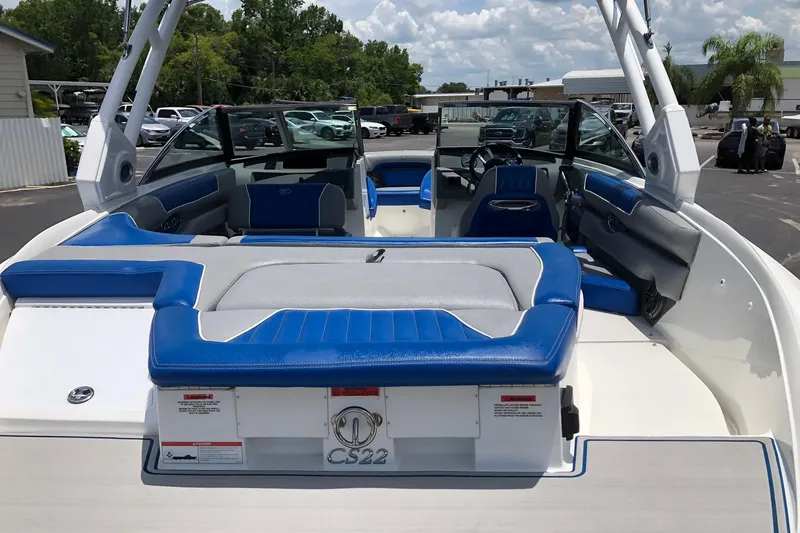 Slide: The Image of 2021 Cobalt CS22 boat interior with blue and gray seating, parked outdoors. - 15