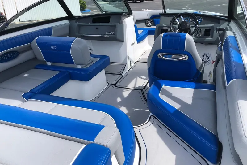 Slide: The Image of 2021 Cobalt CS22 boat interior with blue and gray seating, modern dashboard, and spacious layout. - 24