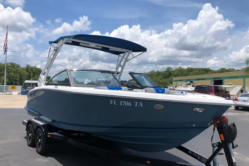 Slide: The Image of 2021 Cobalt CS22 boat on trailer under blue sky, parked outdoors. - 4