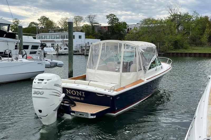 Slide: The Image of 2018 Hunt Yachts Harrier 25 boat docked, featuring a Mercury 300 outboard engine. - 10