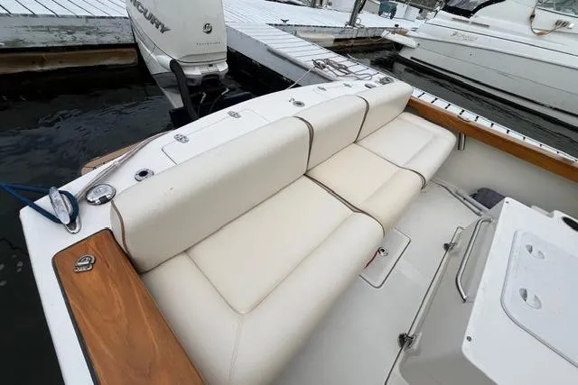 Slide: The Image of 2018 Hunt Yachts Harrier 25 with white seating, docked near other boats. - 13