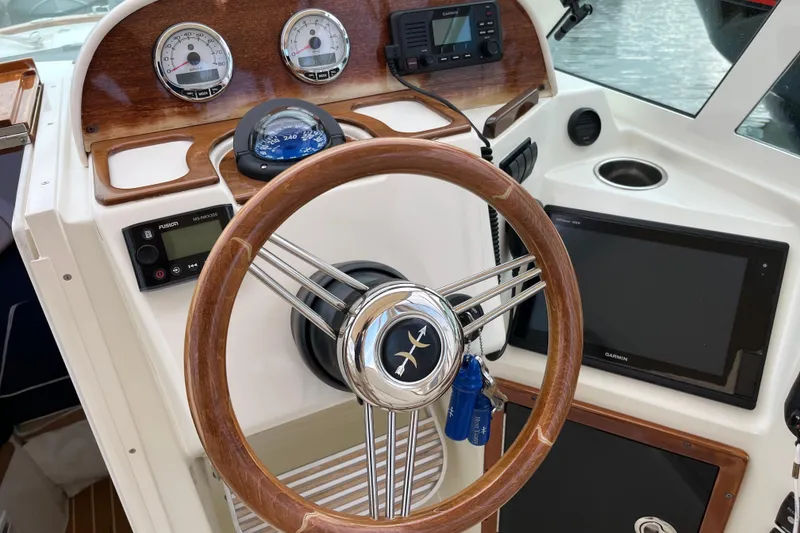 Slide: The Image of 2018 Hunt Yachts Harrier 25 dashboard with wooden steering wheel and navigation instruments. - 15