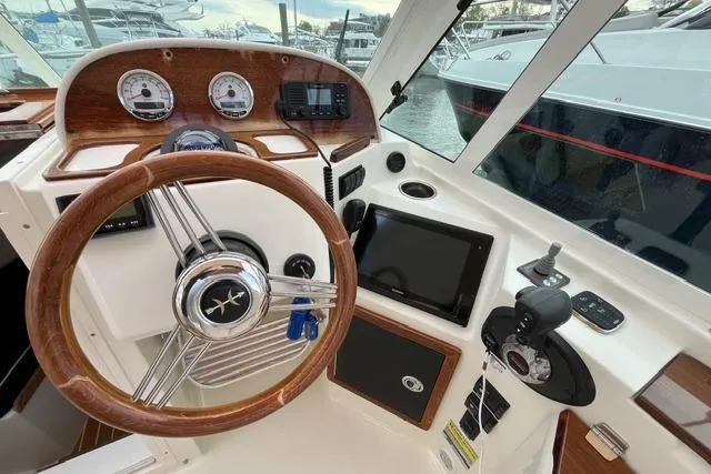 Slide: The Image of 2018 Hunt Yachts Harrier 25 helm with wooden steering wheel and modern navigation instruments. - 17