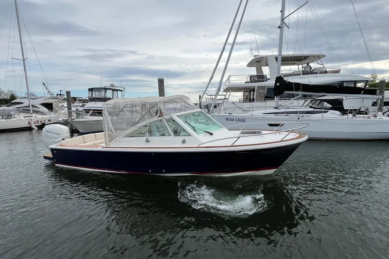 Slide: The Image of 2018 Hunt Yachts Harrier 25 in marina, surrounded by other boats under cloudy sky. - 2