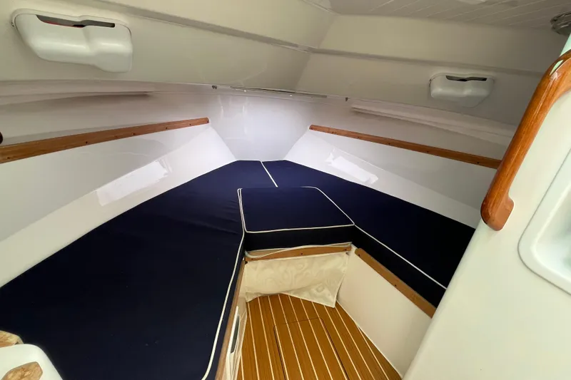 Slide: The Image of 2018 Hunt Yachts Harrier 25 cabin interior with navy cushions and wooden accents. - 20
