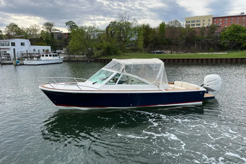 Slide: The Image of 2018 Hunt Yachts Harrier 25 boat on calm water, featuring a sleek design and canopy. - 6