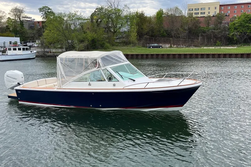 Slide: The Image of 2018 Hunt Yachts Harrier 25 boat on calm water, featuring a sleek design and canopy. - 9