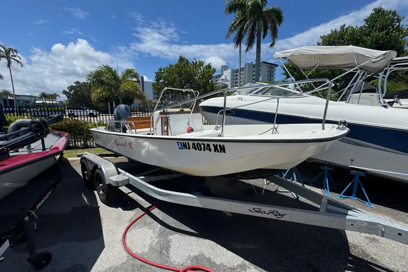 The Image of 1988 Boston Whaler 170 Montauk boat on trailer, parked outdoors under clear sky. - 0