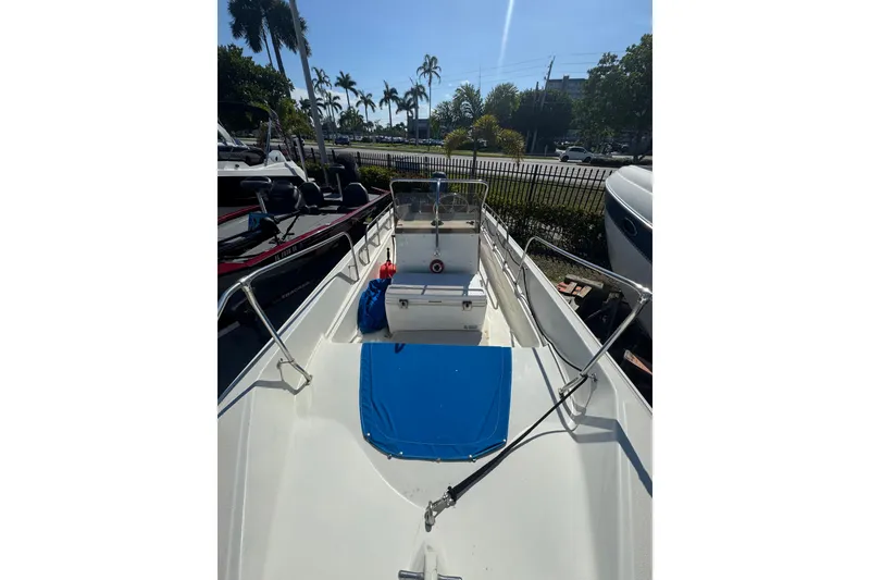 Slide: The Image of 1988 Boston Whaler 170 Montauk boat with blue cover, docked outdoors. - 9