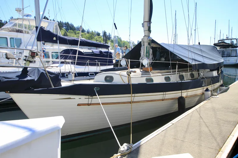 Slide: The Image of 1981 Ta-Shing Panda 40 sailboat docked at marina, covered with navy blue tarps. - 15