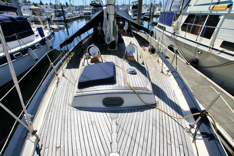 Slide: The Image of 1981 Ta-Shing Panda 40 sailboat docked at marina, showcasing wooden deck and nautical equipment. - 20