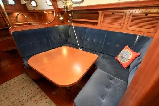Slide: The Image of 1981 Ta-Shing Panda 40 yacht interior with blue cushioned seating and wooden table. - 50