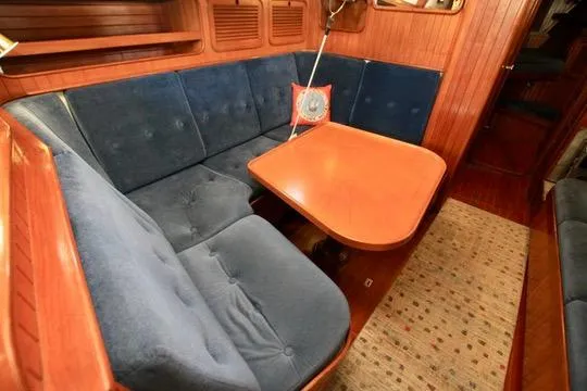 Slide: The Image of Cozy 1981 Ta-Shing Panda 40 yacht interior with blue cushioned seating and wooden table. - 51